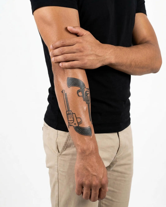 INKON Dos Revólveres tatuaje semi-permanente aplicado en un hombre – diseño de 4 x 7 in (10x17cm), apariencia de tinta realista, dura 10 días