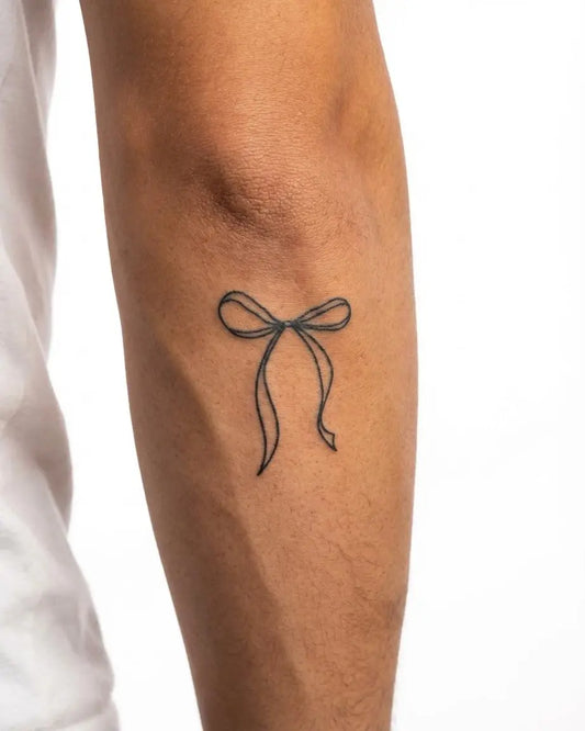 INKON Moño de Listón tatuaje semi-permanente aplicado en un hombre – diseño de 2 x 2 in (5x5cm), apariencia de tinta realista, dura 10 días