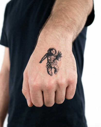 INKON Astronauta Flotando tatuaje semi-permanente aplicado en un hombre – diseño de 2 x 2 in (5x5cm), apariencia de tinta realista, dura 10 días